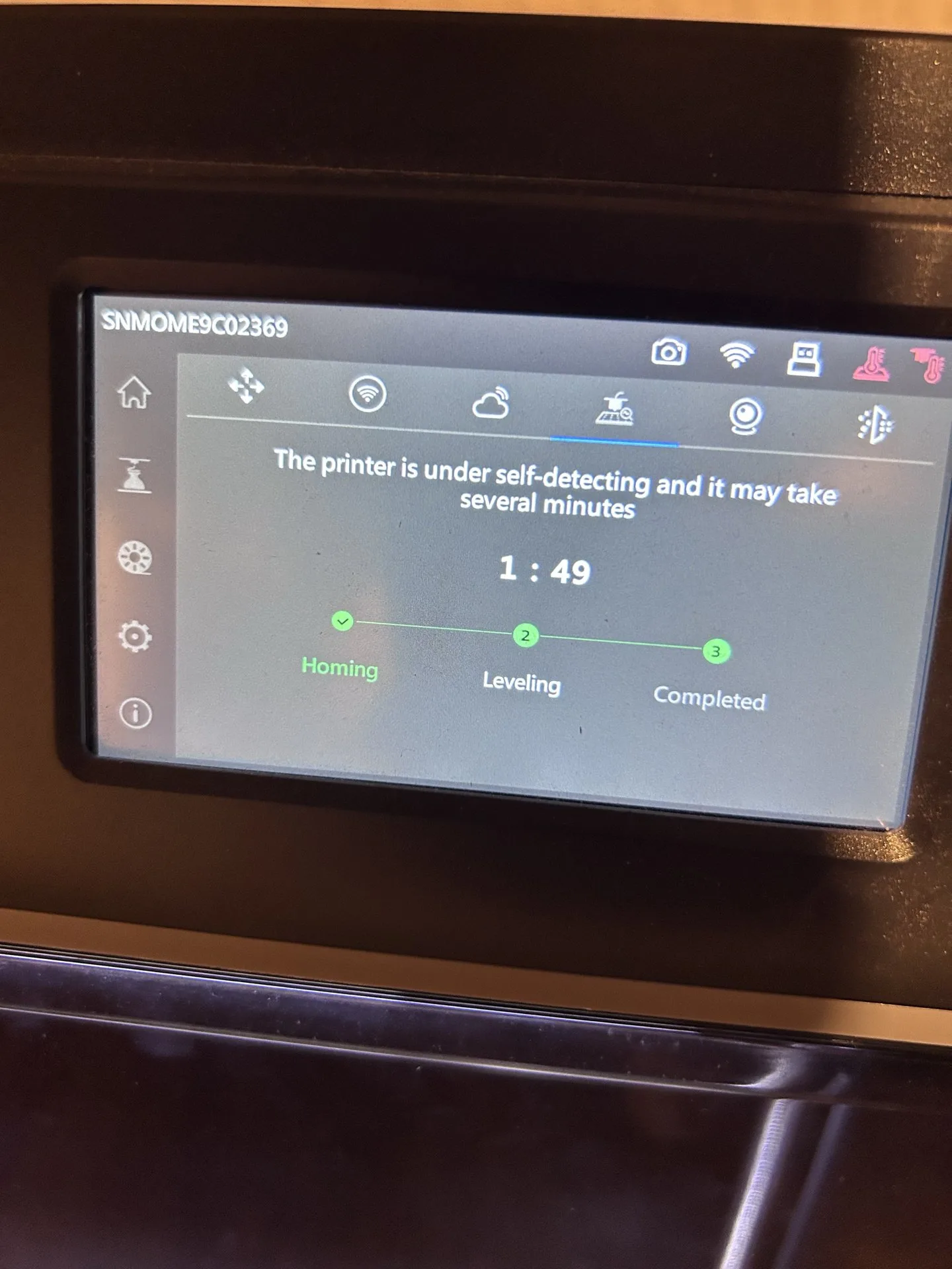 The printer self-check screen showing homing completed and leveling in progress.